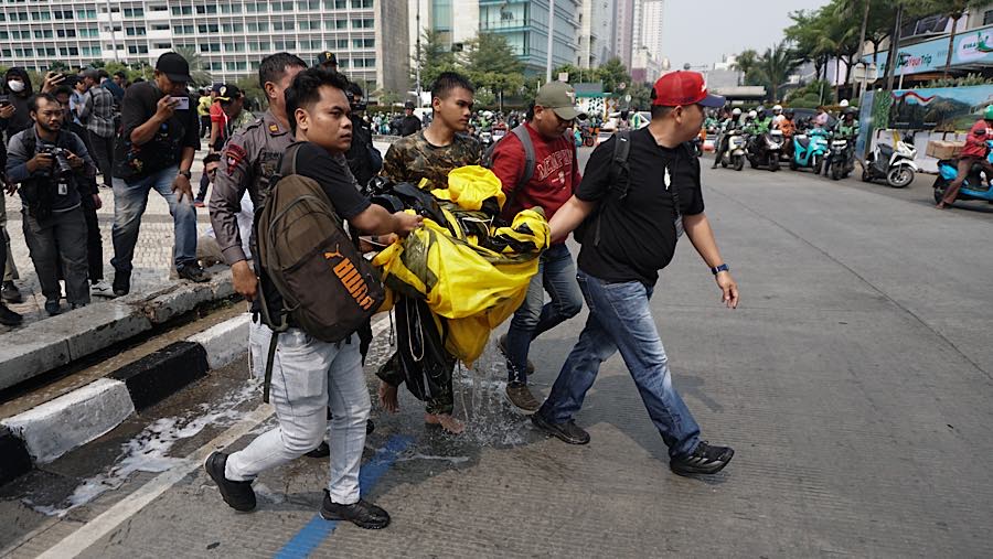 Tak lama kemudian spanduk itu diturunkan oleh aparat kepolisian dari atas Patung Selamat Datang. (Bloomberg Technoz/Andrean Kristianto)