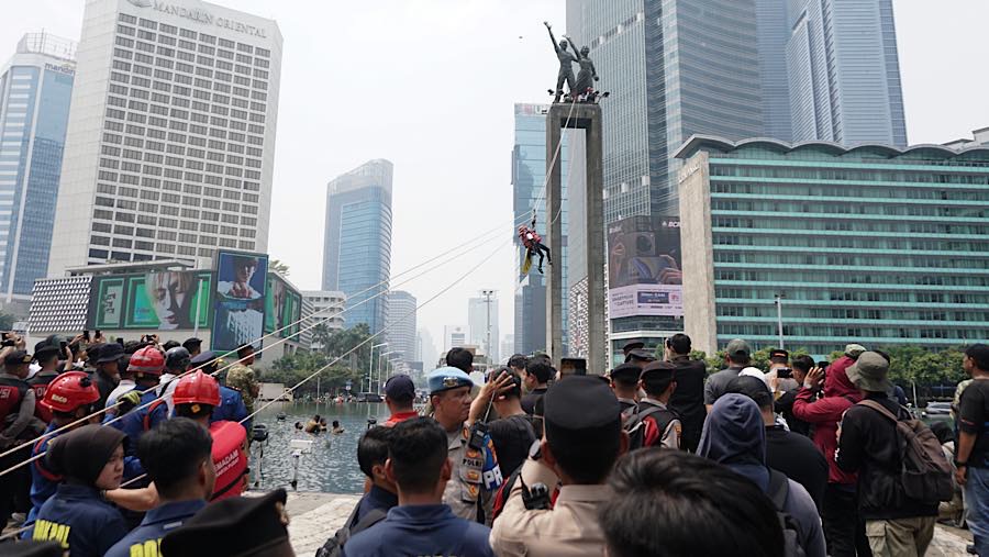 Aktivis Greenpeace melakukan aksi di atas Patung Selamat Datang, Bundaran HI, Jakarta, Selasa (20/10/2026). (Bloomberg Technoz/Andrean Kristianto)