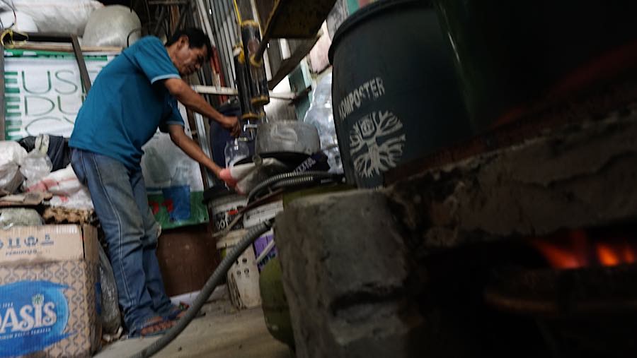 Pengurus Bank Sampah RW 01 Karet Kuningan menuangkan bahan bakar alternatif ke dalam wadah di Jakarta, Rabu (21/10/2026). (Bloomberg Technoz/Andrean)