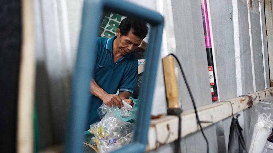 Dadang meniliah sampah plastik di Bank Sampah RW 01 Karet Kuningan, Jakarta, Rabu (21/10/2026). (Bloomberg Technoz/Andrean Kristianto)