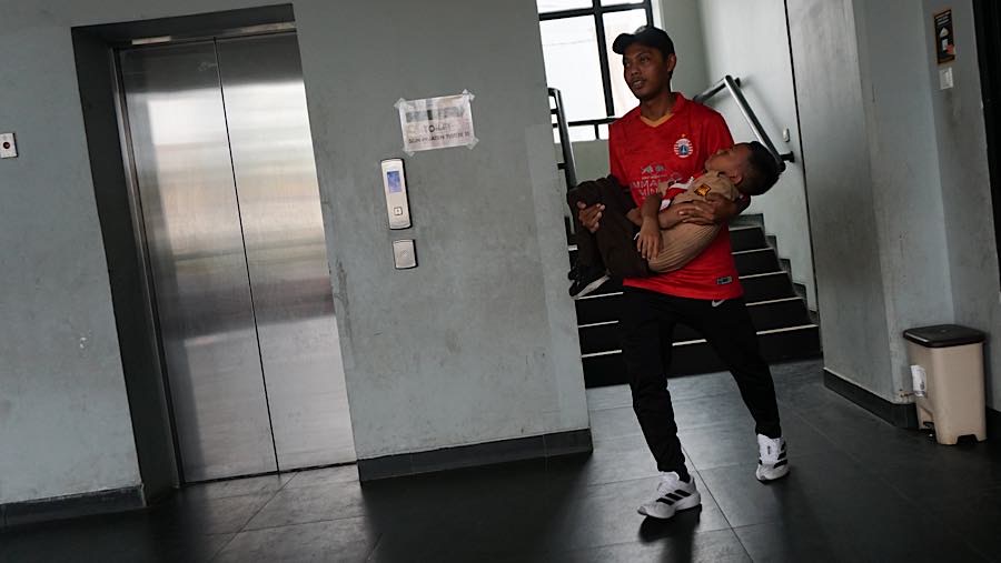 Tak lama kemudian, seorang guru turun melalui tangga dan menggendong siswa yang terkulai lemas. (Bloomberg Technoz/Andrean Kristianto)