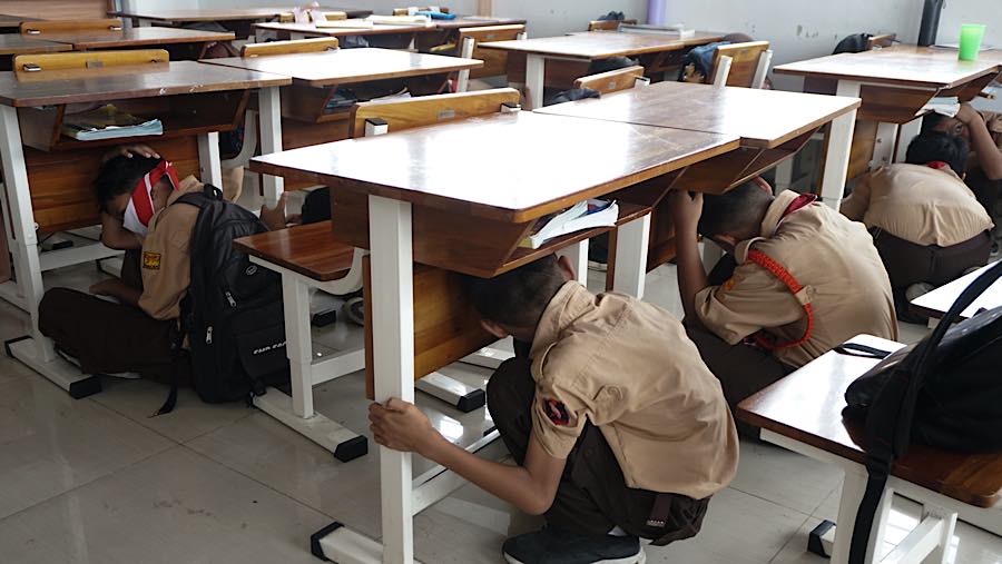 Murid berlindung di bawah meja saat simulasi bencana gempa bumi di SDN Pejaten Timur 11, Jakarta, Rabu (21/10/2026). (Bloomberg Technoz/Andrean K)
