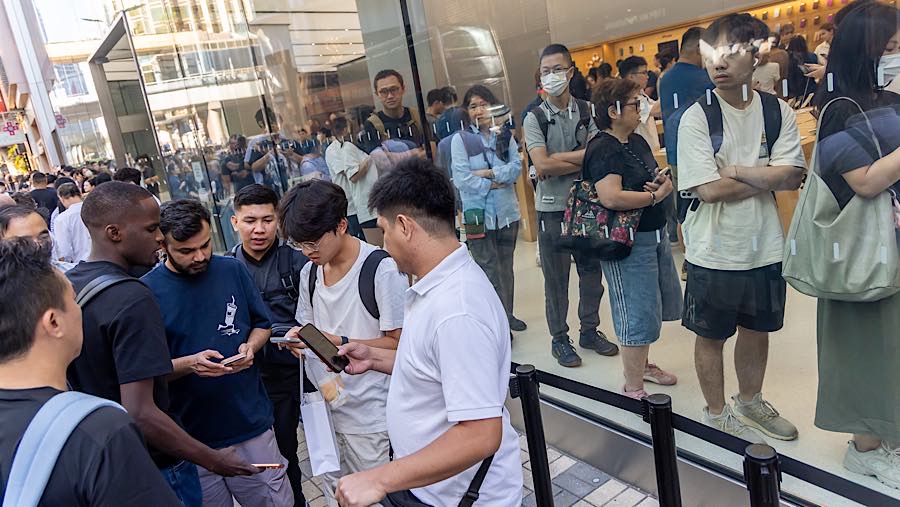 Reseller menawarkan iPhone Duo yang baru dibeli di depan toko Apple di Canton Road, Hong Kong, Tiongkok, Jumat (23/10/2026). (Paul Yeung/Bloomberg)