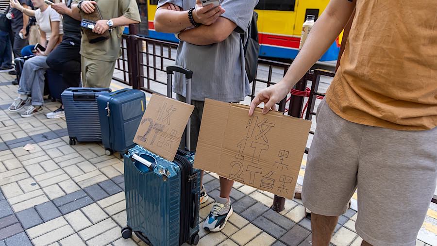 Reseller menawarkan iPhone Duo yang baru dibeli di depan toko Apple di Canton Road, Hong Kong, Tiongkok, Jumat (23/10/2026). (Paul Yeung/Bloomberg)