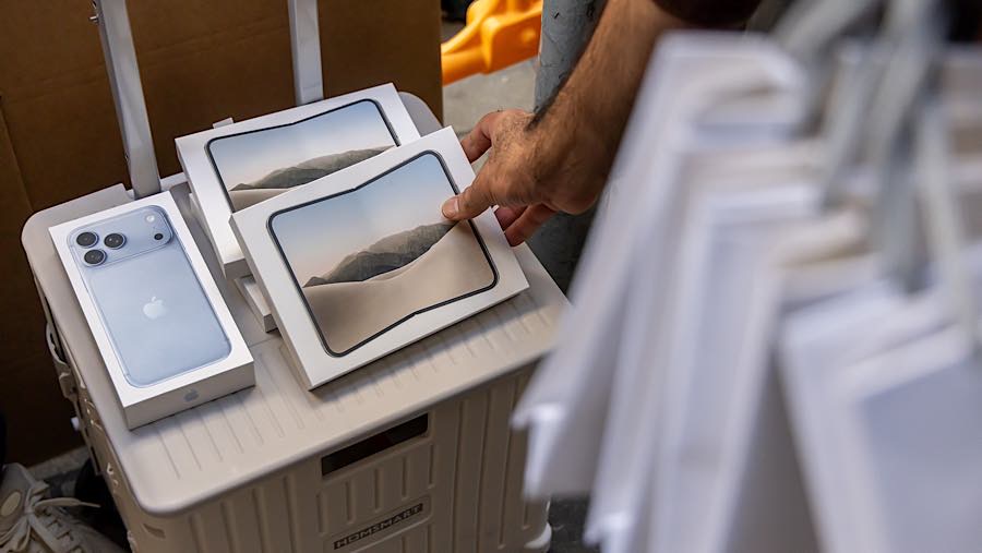 Kotak-kotak berisi iPhone Duo yang baru saja dibeli diletakkan di atas troli pengecer di Hong Kong, Tiongkok, Jumat (23/10/2026). (Paul Yeung/Bloomber