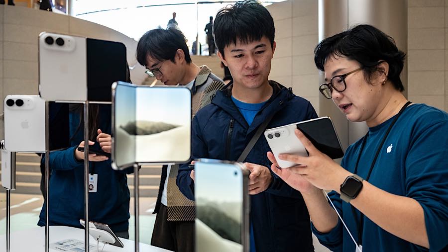 Pelanggan mencoba iPhone Duo saat hari petama penjualan di toko Apple Jing'an, Shanghai, Tiongkok, Jumat (23/10/2026). (Qilai Shen/Bloomberg)