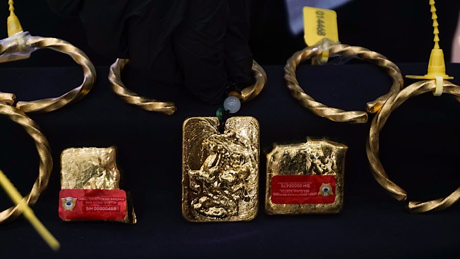 Petugas menata barang bukti emas saat rilis penindakan ekspor emas ilegal di Kantor Pusat Bea Cukai, Senin (26/10/2026). (Bloomberg Technoz/Andrean K)