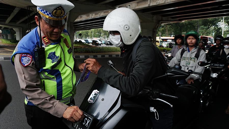 Anggota Satlantas melakukan sosialisasi Operasi Patuh Jaya 2026 di jalan RS Fatmawati, Jakarta, Rabu (28/10/2026). (Bloomberg Technoz/Andrean K)