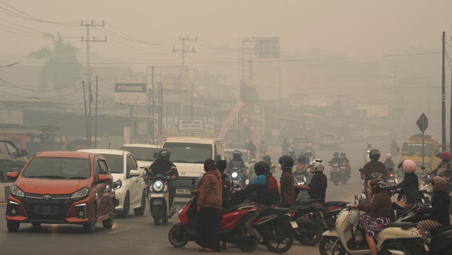 Para pengendara melintasi kabut tebal akibat kebakaran hutan di Palangkaraya, Kalimantan Tengah. (Dimas Ardian/Bloomberg)